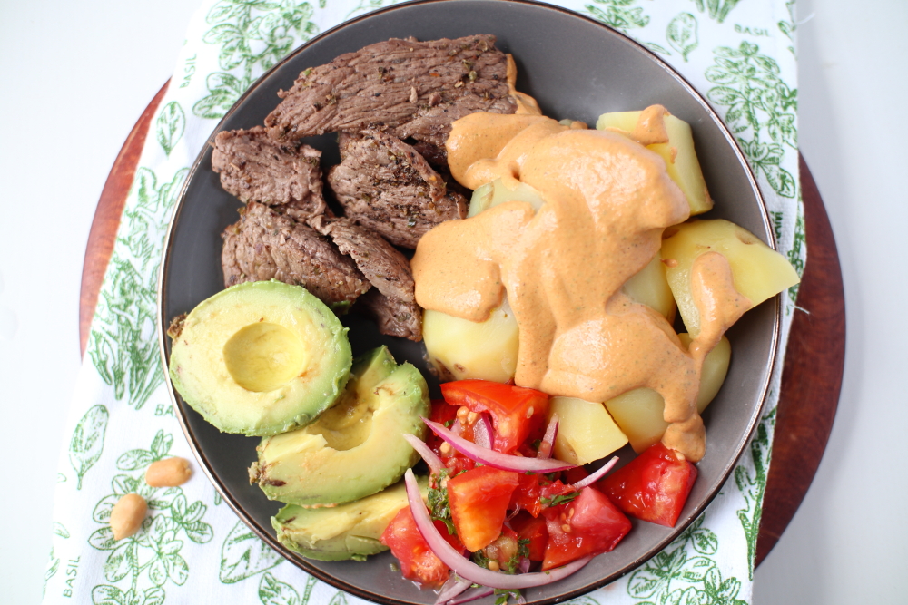 ecuadorian-peanut-sauce-on-potatoes-with-avocado-meat-encebollado-top-view