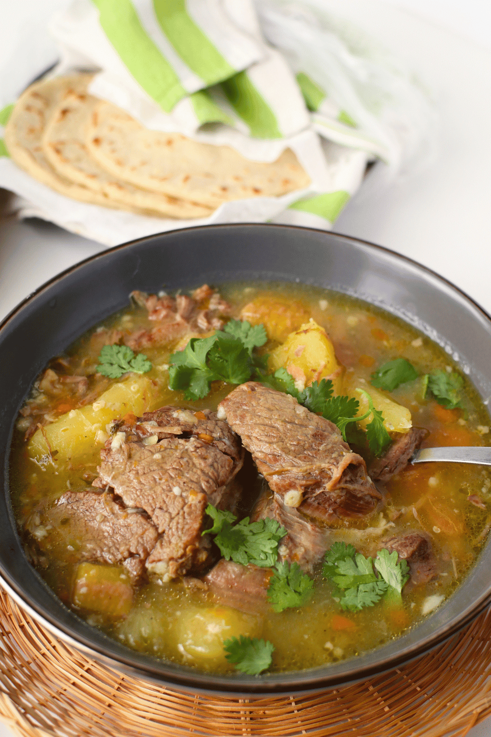 top side view of latin beef soup with tortillas in background