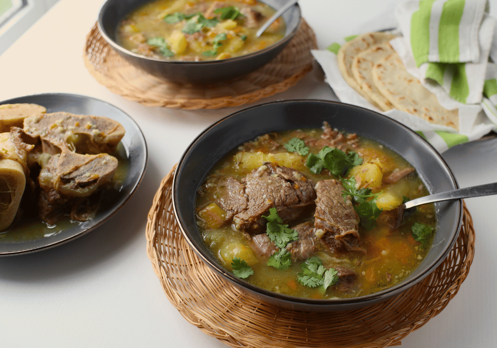 side view of latin beef soup bowls, tortillas, and broth bones