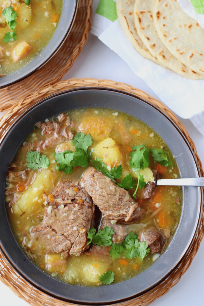 top view of latin beef soup and tortillas