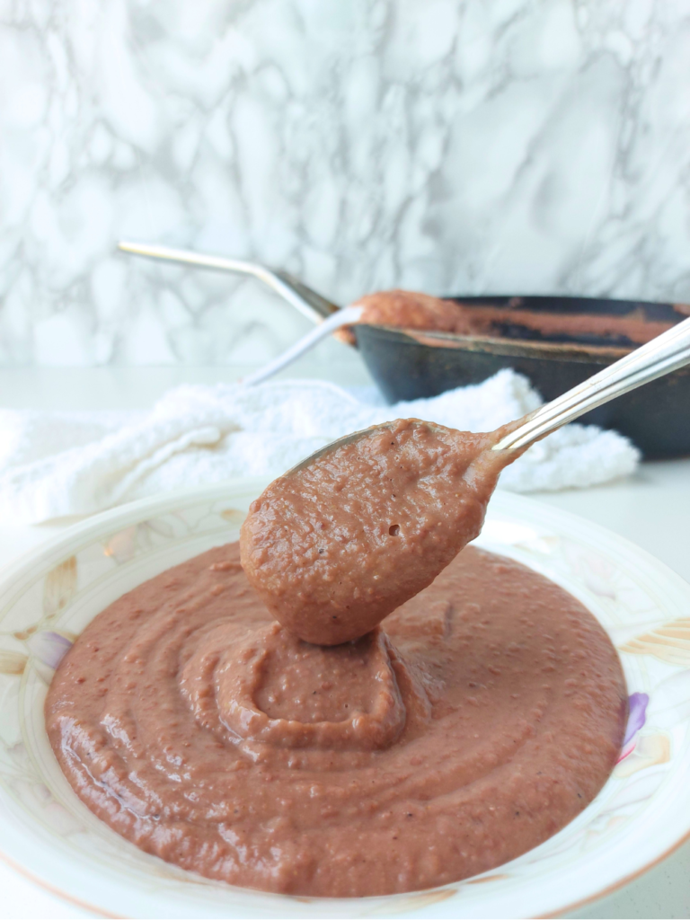 close up of frijoles red bean honduran dip with spoon and bowl