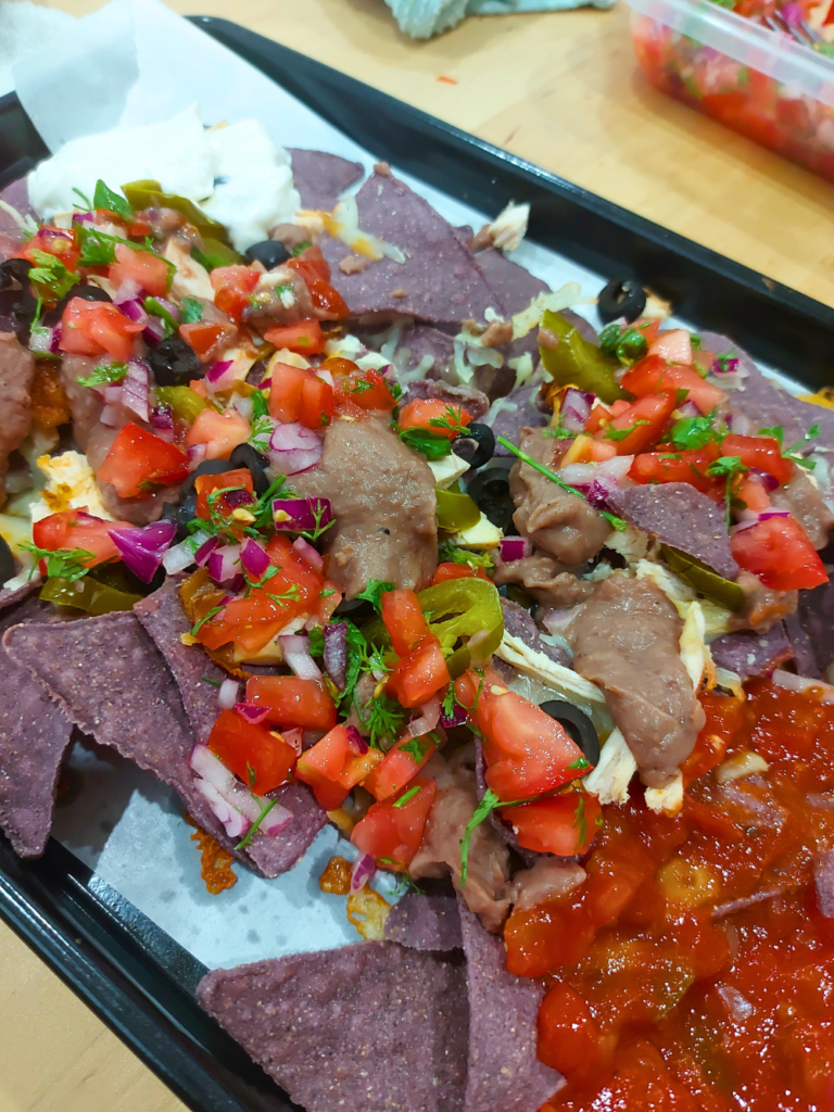 purple corn chips nachos with various toppings close up